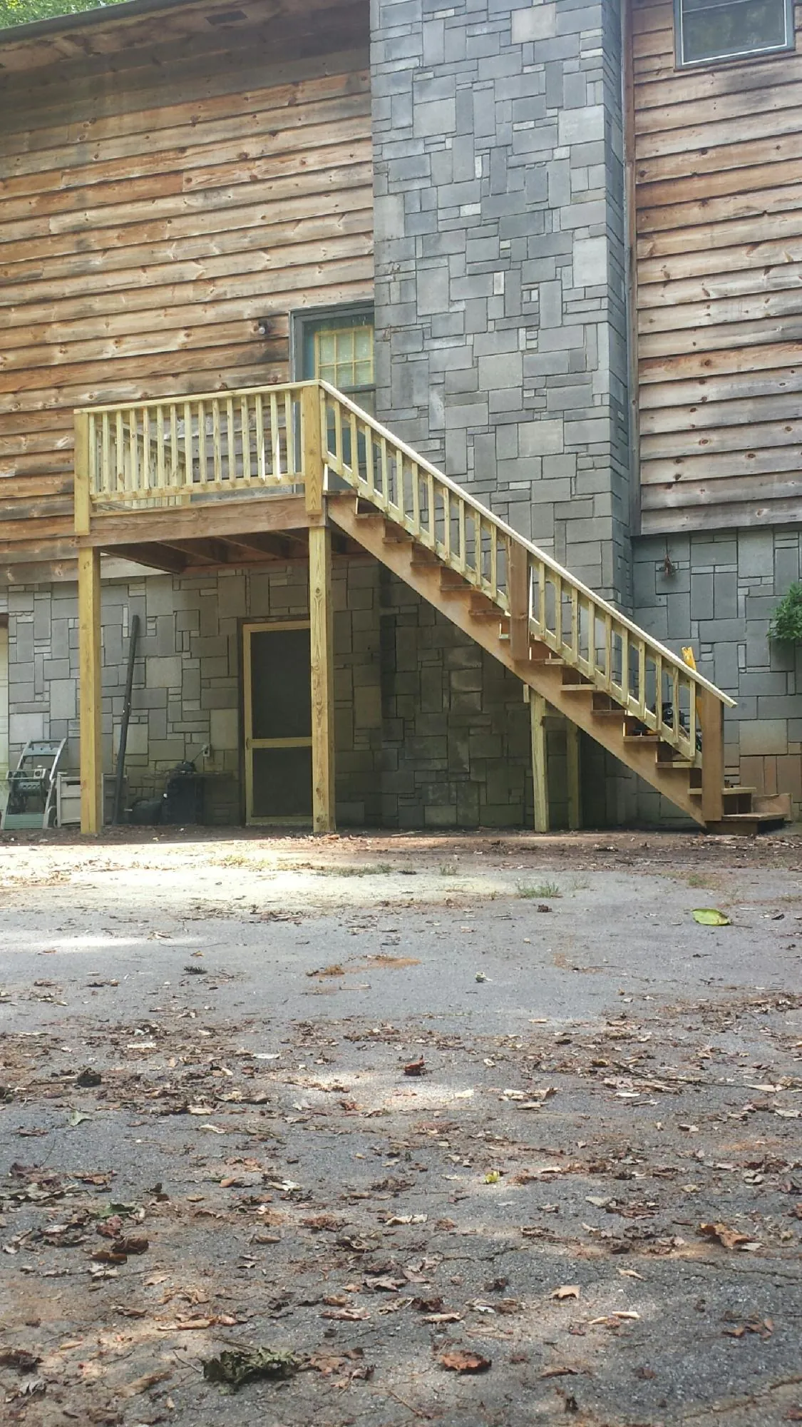 New pressure treated deck and stair landing on a log home in Guyton