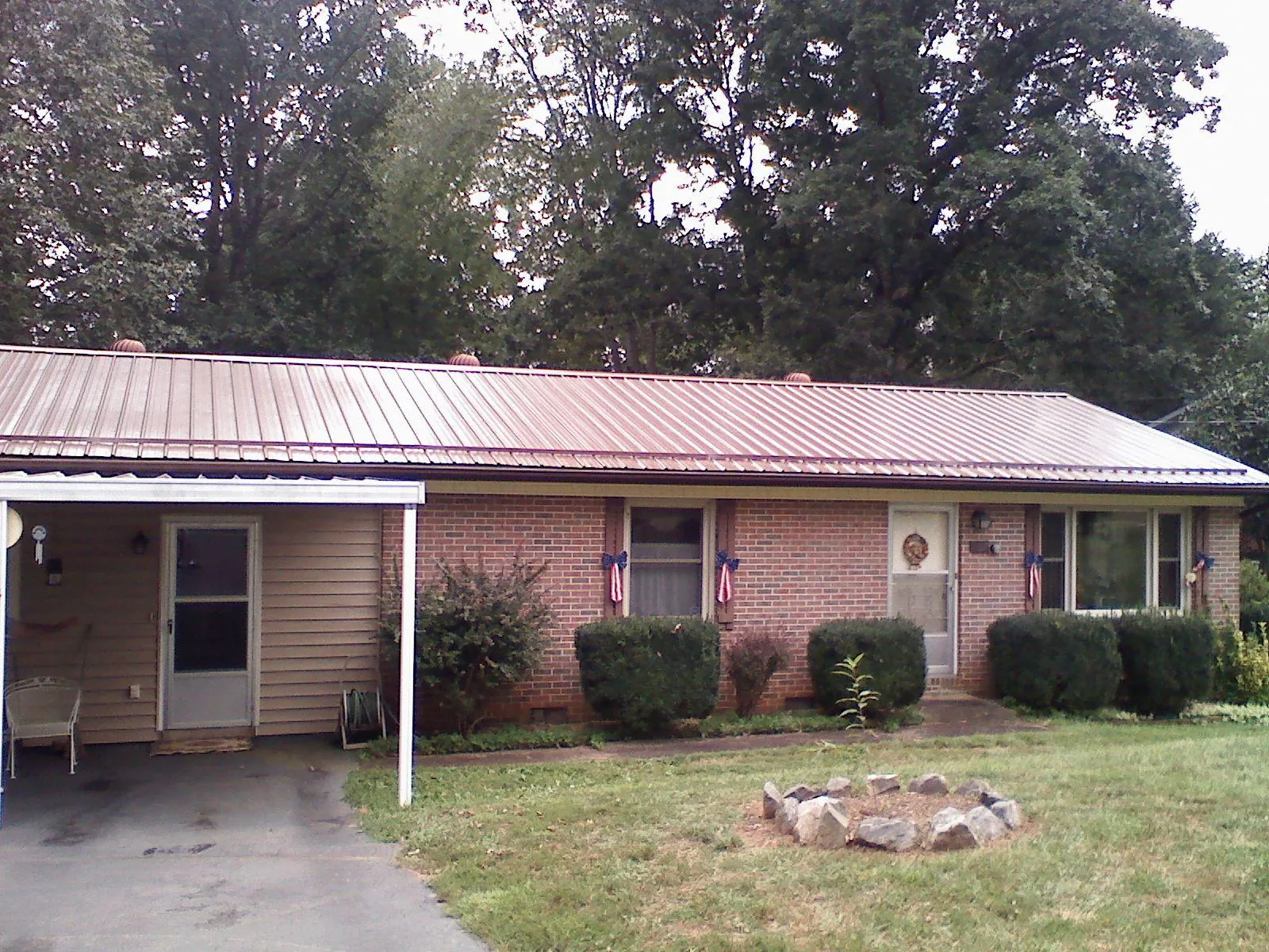 Bronze metal roof and carport on a brick ranch home — Roof Repair work by our crew in Guyton