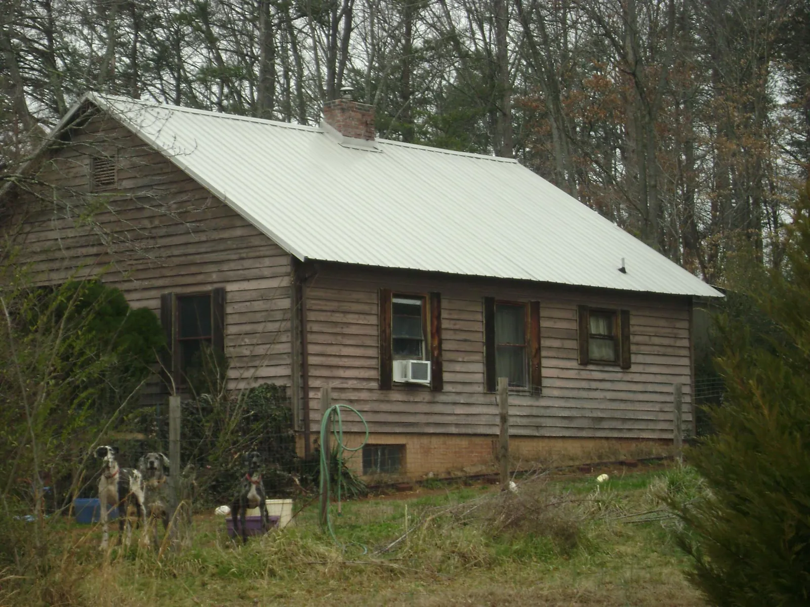 White metal roof on an old wood sided farmhouse, from a Metal Roof Installation job in Guyton